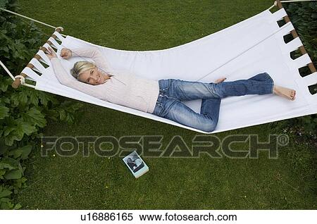 Stock Photography - Woman relaxing in hammock smiling. Fotosearch