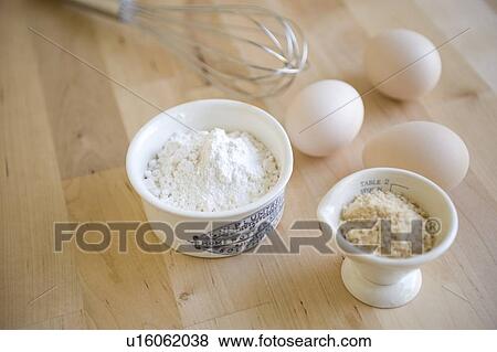 Stock Photo - Flour in cup and eggs. Fotosearch