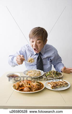 Stock Photo - Businessman eating Chinese food. Fotosearch