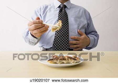 Businessman eating dumplings View Large Photo Image Stock Photo - Businessman eating dumplings. Fotosearch