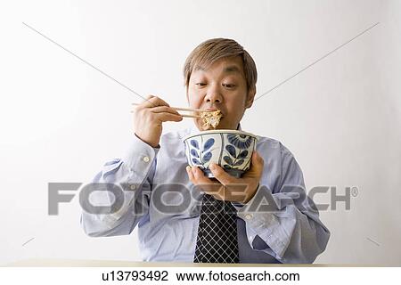 Businessman eating Japanese food View Large Photo Image Stock Image - Businessman eating Japanese food. Fotosearch
