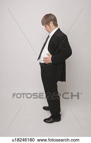 Businessman looking at his belly View Large Photo Image Stock Image - Businessman looking at his belly. Fotosearch