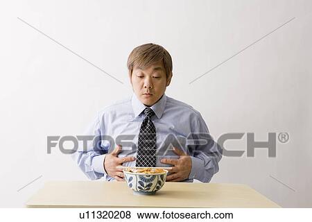Stock Photo - Businessman sitting in front of food. Fotosearch
