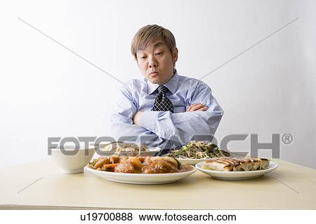 Businessman sitting in front of food View Large Photo Image Stock Photo - Businessman sitting in front of food. Fotosearch