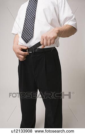 Stock Photo - Businessman tightening belt. Fotosearch