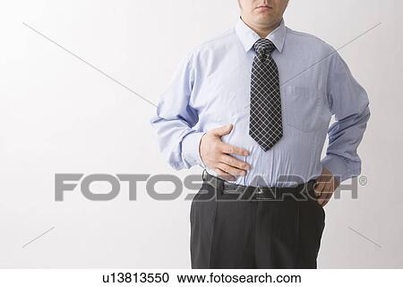 Businessman touching his belly View Large Photo Image Stock Image - Businessman touching his belly. Fotosearch