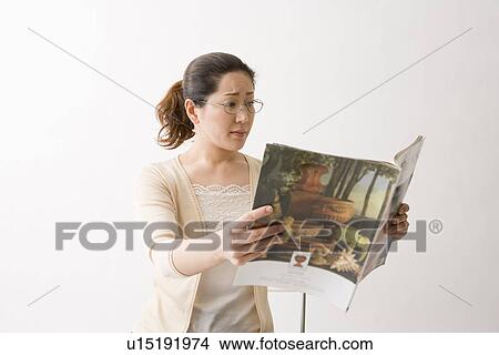 Picture - Mature woman reading magazine. Fotosearch