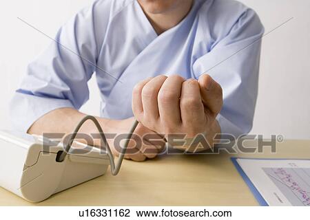 Mid adult man checking blood pressure View Large Photo Image Stock Image - Mid adult man checking blood pressure. Fotosearch