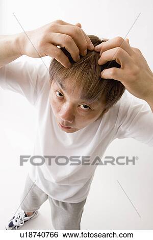 Stock Photograph - Mid adult man checking hair. Fotosearch