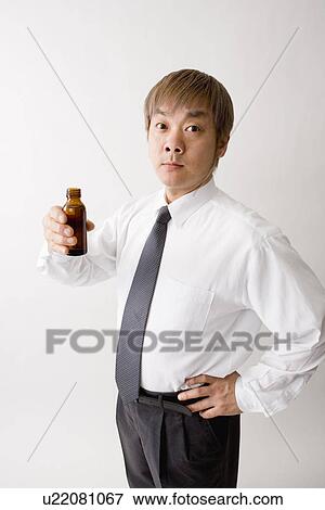 Stock Photo - Mid adult man drinking energy drink. Fotosearch