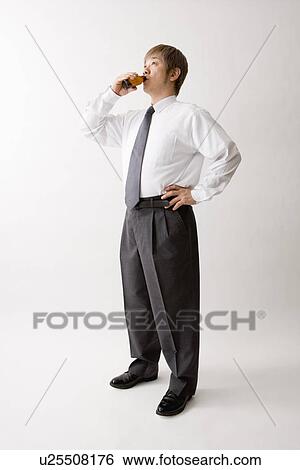 Stock Photograph - Mid adult man drinking energy drink. Fotosearch