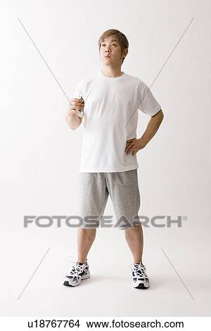 Picture - Mid adult man holding drink. Fotosearch