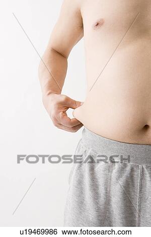 Stock Photograph - Mid adult man pinching fat. Fotosearch