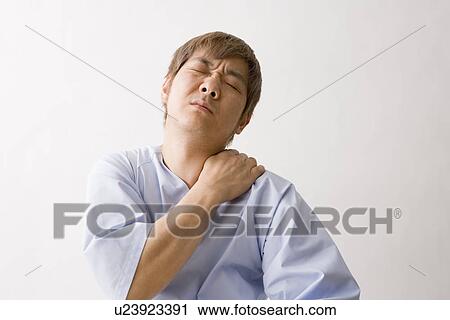 Stock Image - Mid adult man suffering pain in shoulder. Fotosearch