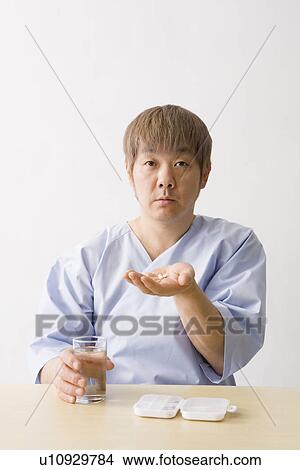 Mid adult man taking pills View Large Photo Image Picture - Mid adult man taking pills. Fotosearch