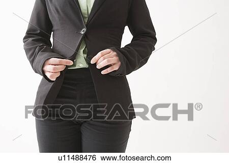 Stock Photograph - Mid adult woman buttoning jacket. Fotosearch