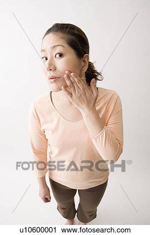 Stock Image - Mid adult woman checking her skin. Fotosearch
