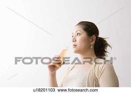Mid adult woman drinking energy drink View Large Photo Image Stock Image - Mid adult woman drinking energy drink. Fotosearch