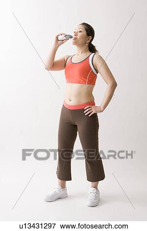 Stock Photo - Mid adult woman drinking energy drink. Fotosearch