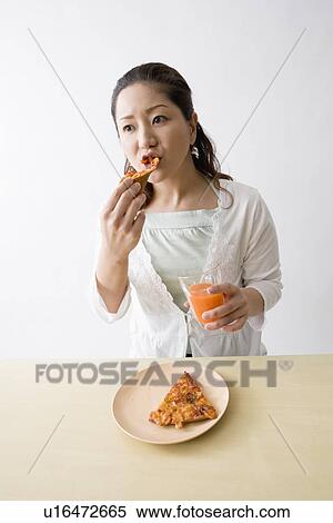 Mid adult woman eating pizza View Large Photo Image Stock Photography - Mid adult woman eating pizza. Fotosearch