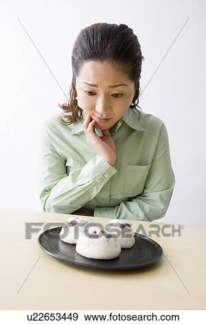 Mid adult woman looking at Japanese sweets View Large Photo Image Stock Photo - Mid adult woman looking at Japanese sweets. Fotosearch