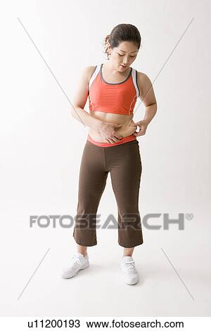 Mid adult woman pinching fat on waist View Large Photo Image Stock Image - Mid adult woman pinching fat on waist. Fotosearch