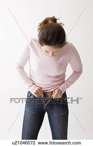 Mid adult woman putting on jeans View Large Photo Image Stock Image - Mid adult woman putting on jeans. Fotosearch