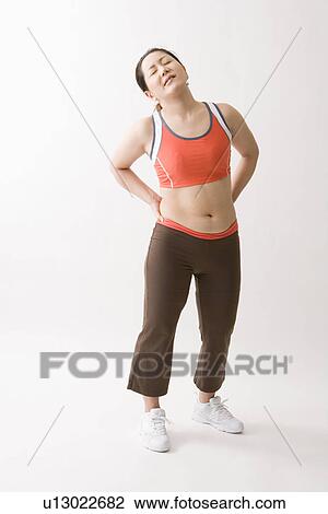 Stock Image - Mid adult woman suffering from pain. Fotosearch