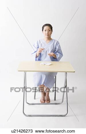 Mid adult woman taking pills View Large Photo Image Stock Image - Mid adult woman taking pills. Fotosearch