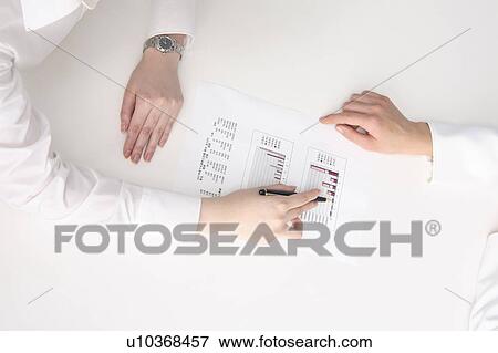 Stock Photo - Hand of woman pointing at a document with a pen, and explaining it. Fotosearch
