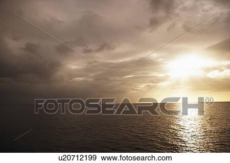 Stock Photo - Clouds over the sea at sunset. Fotosearch