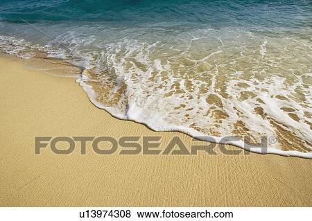 Stock Photo - High angle view of waves breaking on the beach. Fotosearch