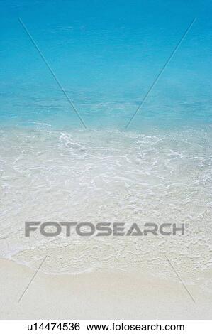 Stock Photograph - High angle view of waves breaking on the beach. Fotosearch