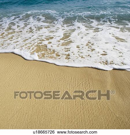 Stock Photograph - High angle view of waves breaking on the beach. Fotosearch