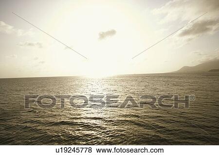 Stock Photo - Sun shining over the sea. Fotosearch