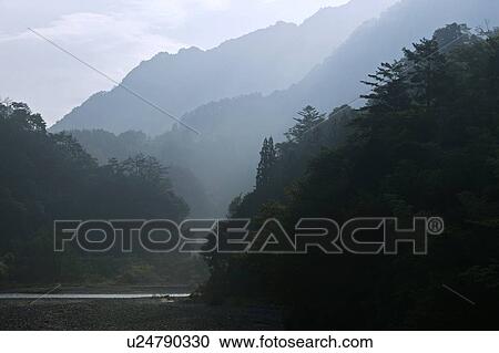 Stock Image - "Mountain And River In Mist, Nagano, Japan". Fotosearch