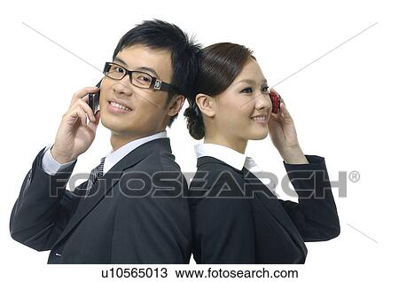 Businessman and a businesswoman talking on mobile phones View Large Photo Image Stock Image - Businessman and a businesswoman talking on mobile phones. Fotosearch