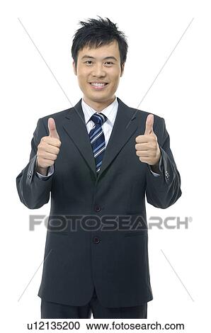 Stock Image - Businessman showing thumbs up and smiling. Fotosearch