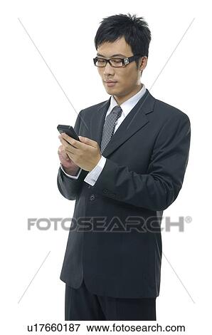 Close-up of a businessman text messaging View Large Photo Image Stock Photo - Close-up of a businessman text messaging. Fotosearch