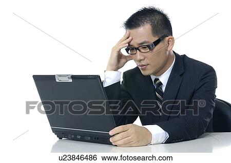 Depressed businessman looking at a laptop View Large Photo Image Stock Photograph - Depressed businessman looking at a laptop. Fotosearch
