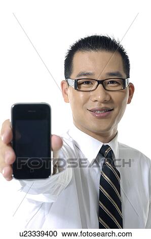 Stock Image - Portrait of a businessman showing a mobile phone. Fotosearch