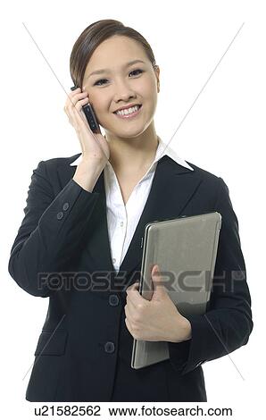 Portrait of a businesswoman holding a laptop and talking on a mobile phone View Large Photo Image Stock Image - Portrait of a businesswoman holding a laptop and talking on a mobile phone. Fotosearch