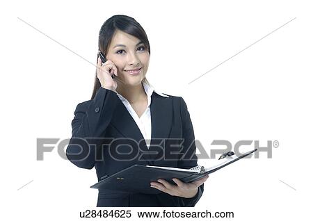Portrait of a businesswoman holding a file and talking on a mobile phone View Large Photo Image Stock Photography - Portrait of a businesswoman holding a file and talking on a mobile phone. Fotosearch