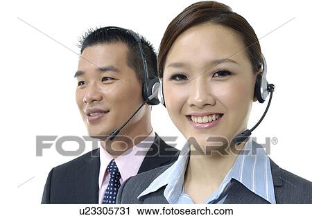 Stock Image - Portrait of a female and a male customer care executives smiling. Fotosearch