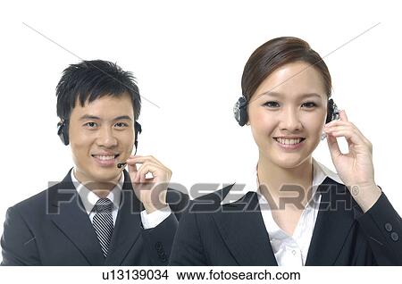 Picture - Portrait of a male and a female customer care executives smiling. Fotosearch
