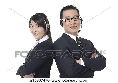 Stock Image - Portrait of a male and a female customer care executives smiling. Fotosearch