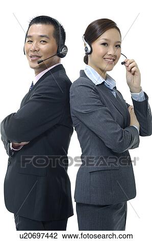 Stock Image - Portrait of a male and a female customer care executives smiling. Fotosearch