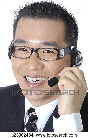 Portrait of a male customer care executive adjusting his headset View Large Photo Image Picture - Portrait of a male customer care executive adjusting his headset. Fotosearch