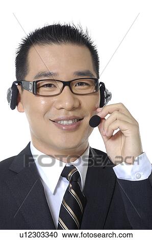 Portrait of a male customer care executive adjusting his headset View Large Photo Image Stock Image - Portrait of a male customer care executive adjusting his headset. Fotosearch