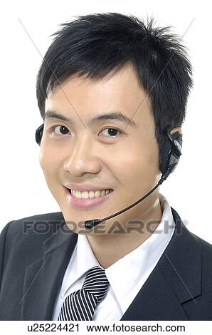 Stock Image - Portrait of a male customer care executive smiling. Fotosearch